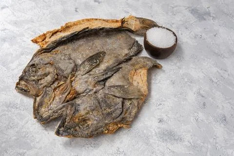 Salted cod on a textured surface with a well of salt. Ingredient of the Fanesca Stock Photos