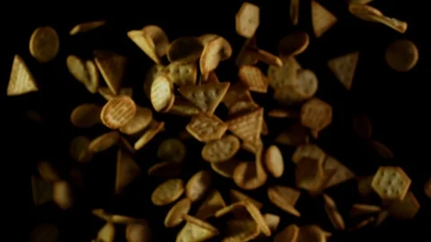 Salted crackers fly after being exploded golden cookies snacks black background Video stock 106733444