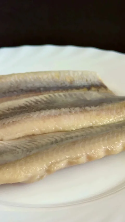 Salted herring fish fillets lying on a white plate Video stock 331975495