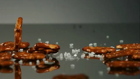 Salted pretzel twists falling on reflective surface Stock Footage 327120851