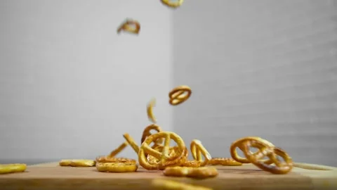 Salted pretzels fall on a cutting board Video stock 194277355