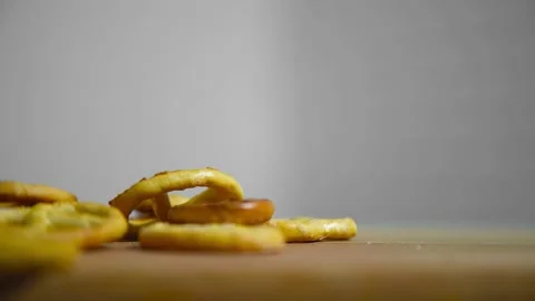 Salted pretzels fall on a cutting board Stock Footage 194277360