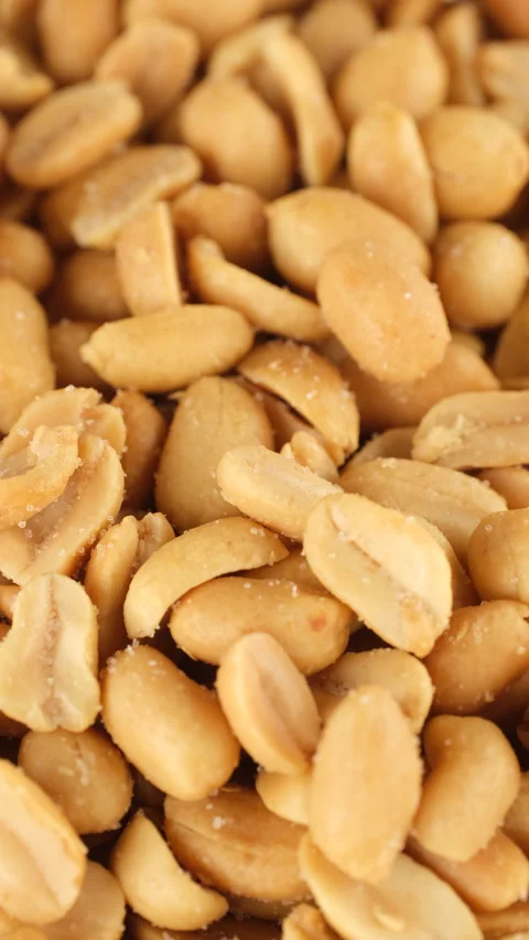 Salted roasted peanuts falling down in plate, close up Stock-Footage 300854551