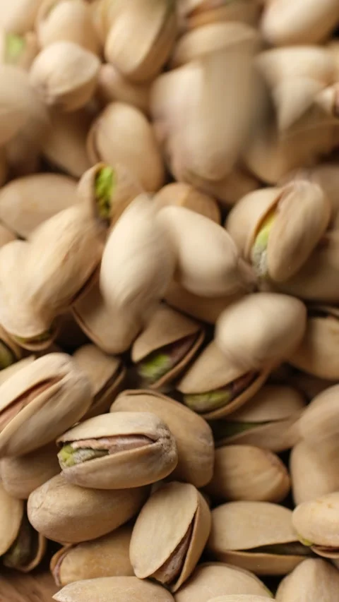 Salted roasted pistachios falling down in bowl Video stock 282542435