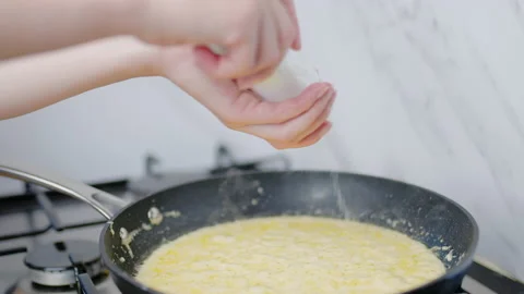 Salting or adding salt into a cream sauce in a frying pan in 4K. Stock Footage 138066355