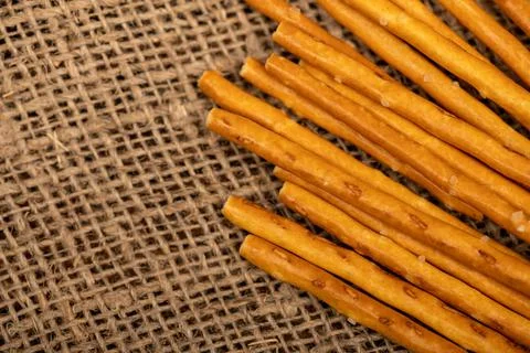 Salty bread strips scattered on a background of coarse homespun fabric. Stock Photos