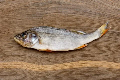 Salty dry river fish perch, bass on a wooden impressive background. Stock Photos