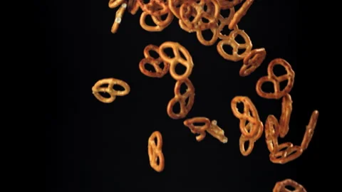 Salty pretzels fly and fall on a black background. Filmed on a high-speed camera Stock Footage 322819935