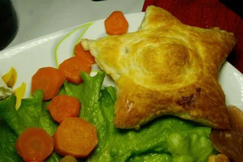 Salty puff pastry in star shape and green salad Stock Photos