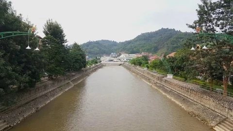 Sam Neua river, dragon lanterns, tree covered mountains and houses in distance Stockbeeldmateriaal 76795287