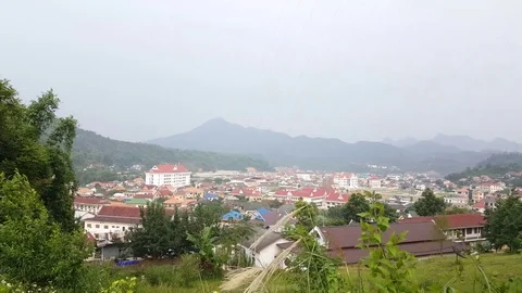 Sam Neua view from above, Lao town in valley surrounded by mountains, trees Vidéo 76812656