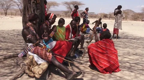 Samburu tribesmen resting against a tree. 库存影片 46528541