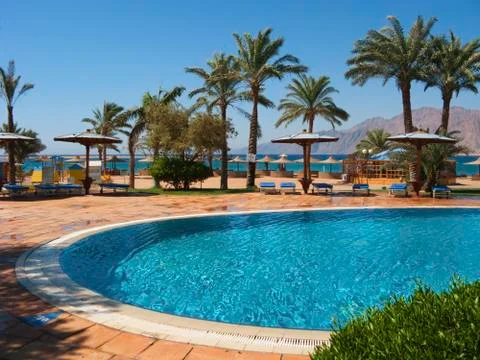 The same blue color of the pool and the sea Stock Photos