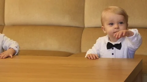 Same cute babies in festive clothes near the table dolly shot Stock Footage 83729720