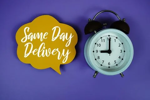 Same Day Delivery text on speech bubble with alarm clock on purple background Stock Photos