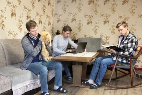 The same man. A man holds a cat in his arms. A man works at a laptop. A man i Foto stock