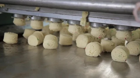 Same pieces of dough fall onto conveyor from dough feeder in bakery. Stock Footage 76447525