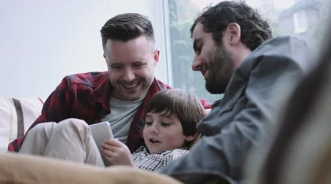 Same sex couple family on the couch watching digital tablet Stock Footage