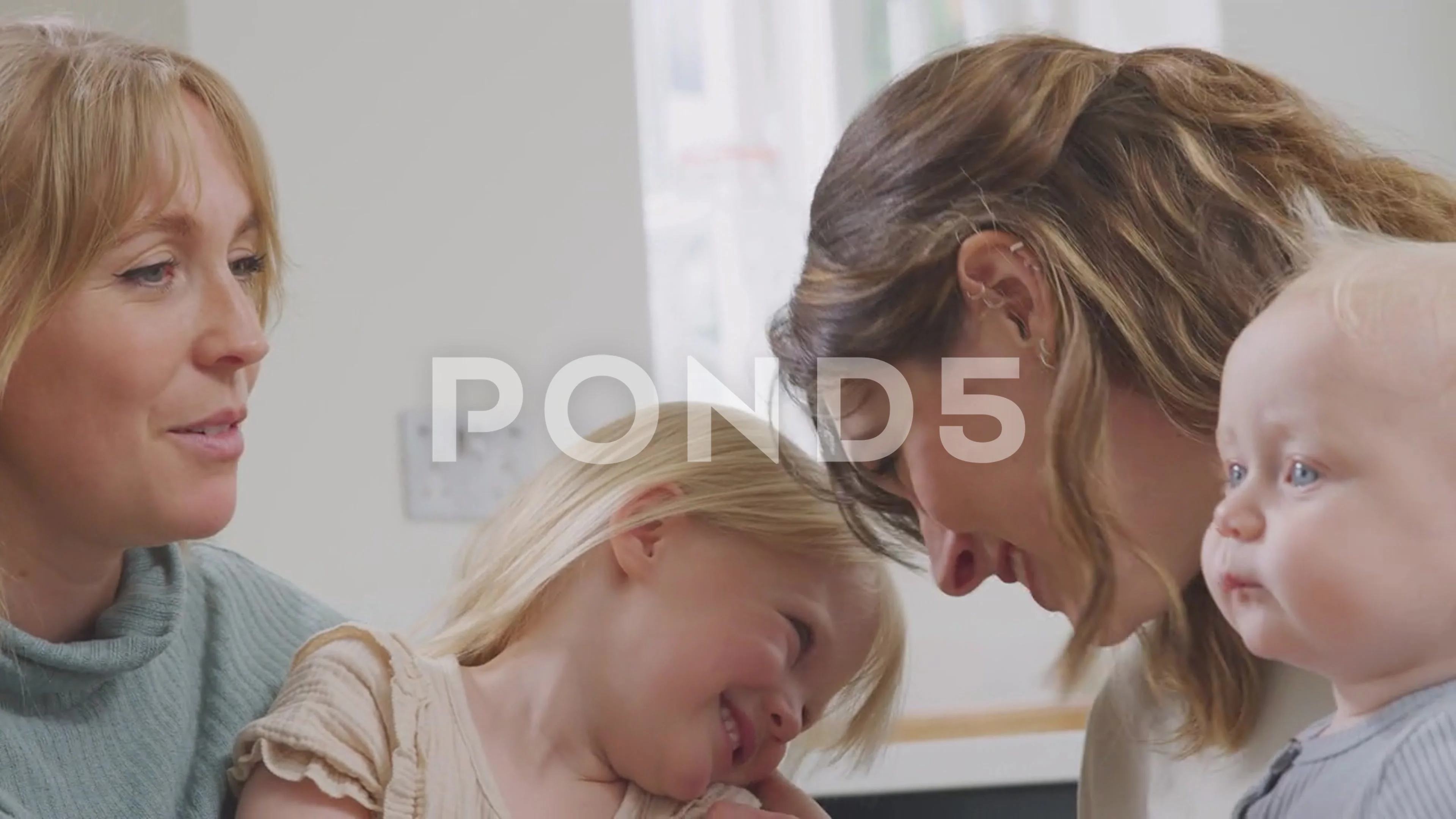 Same Sex Female Couple Having Healthy Breakfast At Home With Daughter And  Baby