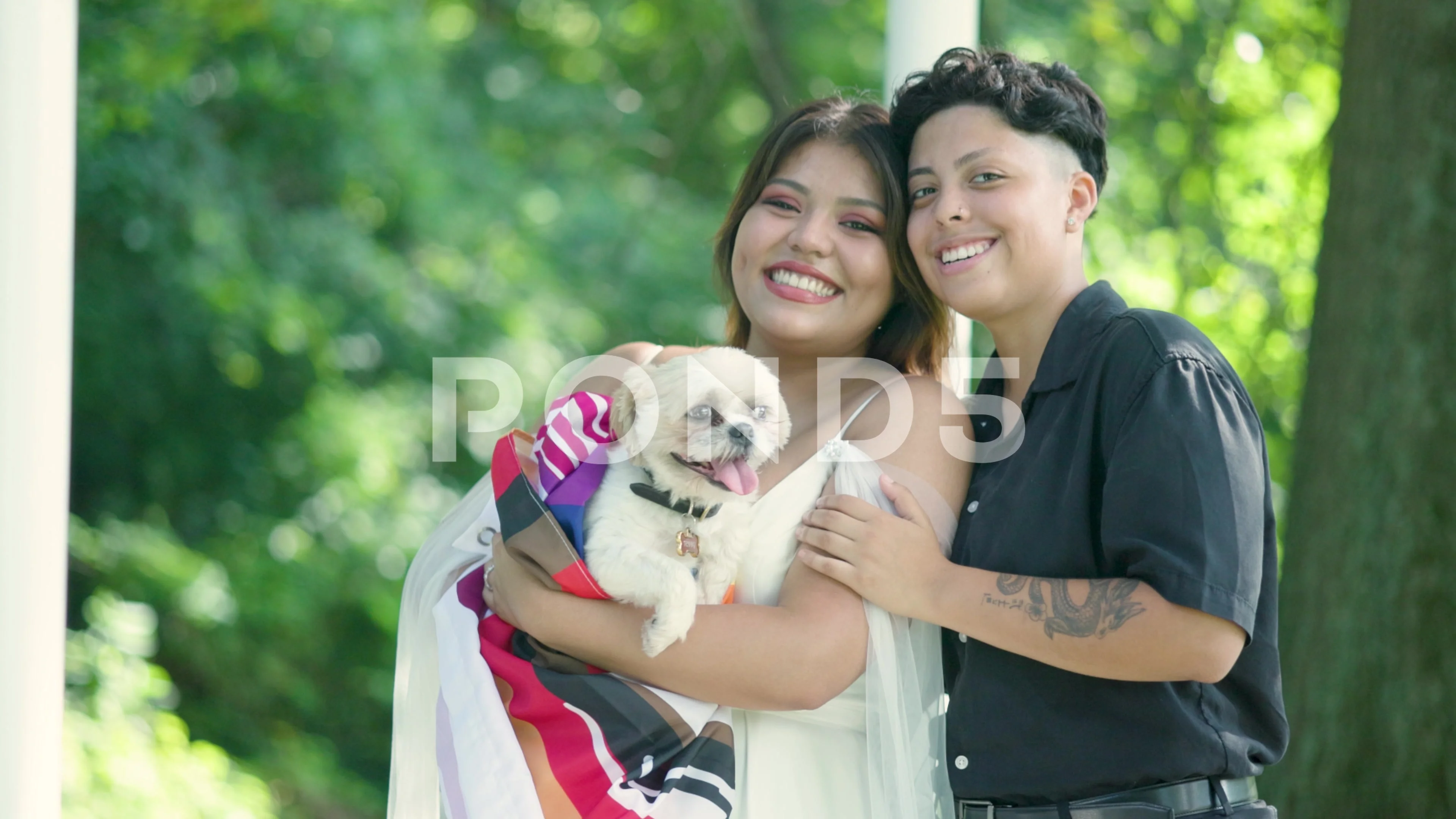 Same-Sex Lesbian Couple Holding Dog with Pride Flag on Wedding Day in