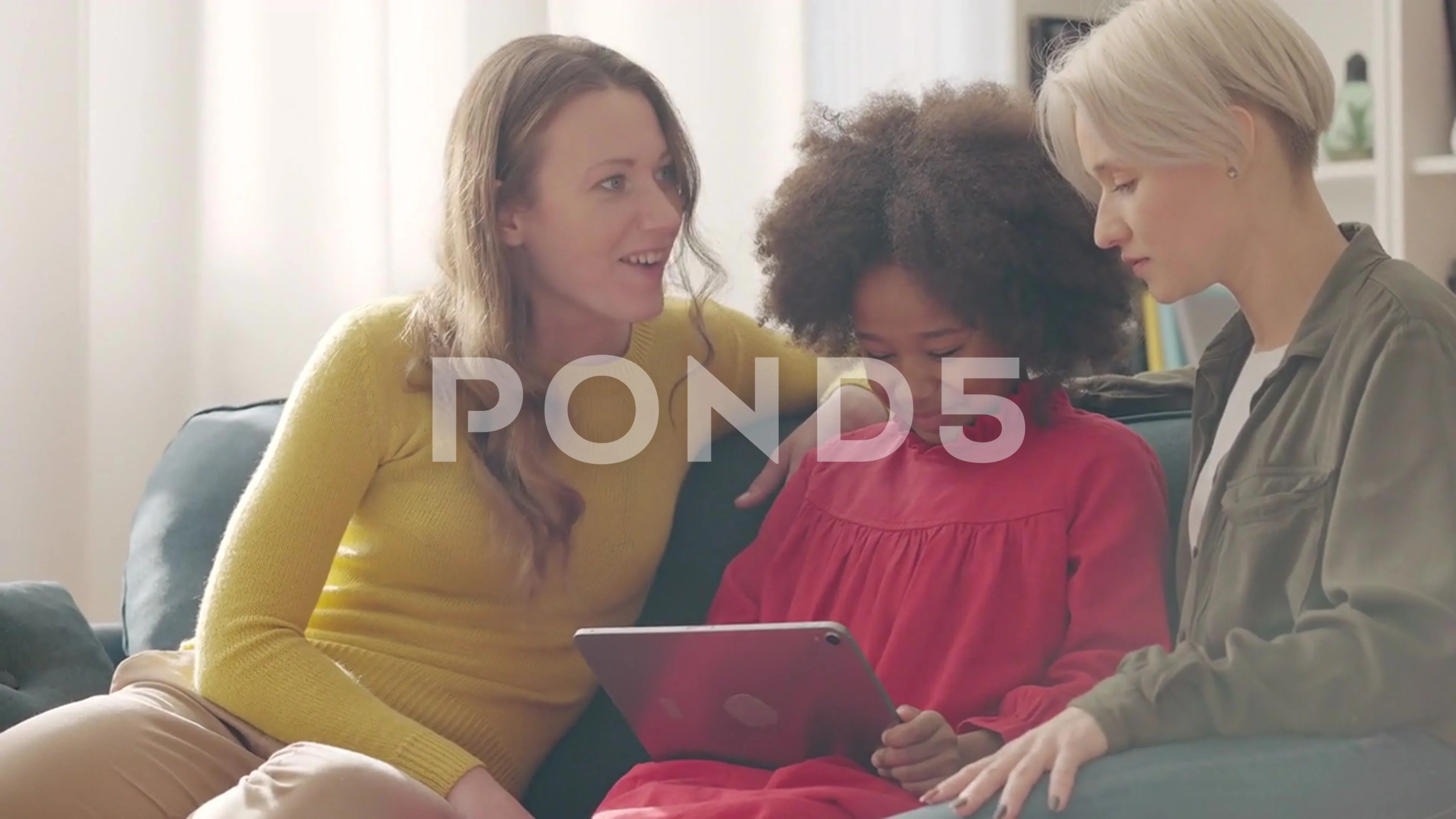 Same-sex parents helping daughter play educational game on tablet, family  time