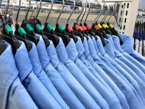 Same Styled Blue Shirts Hanging on a Rack Stock Photos