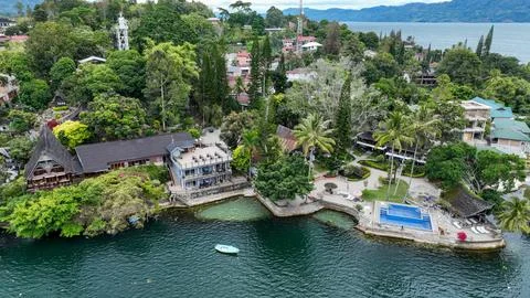Samosir luxury resort, infinity pool overlooks Lake Toba, traditional roofs Stock Photos