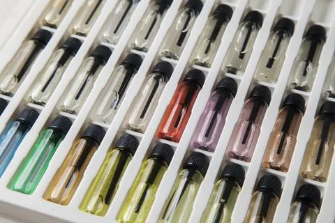 Sample of colored perfume bottles with different types of fragrances and arom Stock Photos