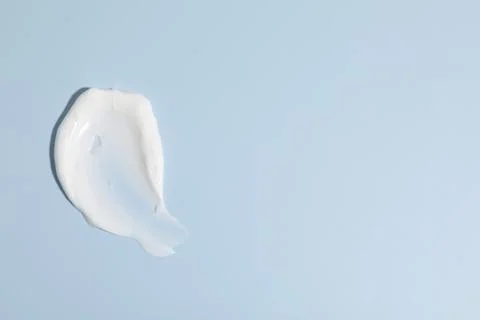 Sample of cream on light blue background, top view. Space for text Stock Photos