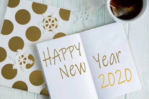 Sample layout of New Year's greetings with snowflakes, open notebook, cup of Stock Photos