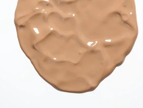 Sample of light brown face cream dripping down on white background Stock Photos