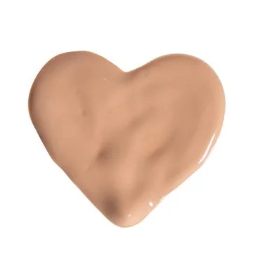 The sample of liquid foundation in shape of heart isolated on white backgroun Fotos Stock
