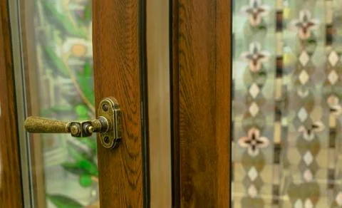 Sample of modern wooden window profile on sill indoors. Door hand in retro st Stock Photos