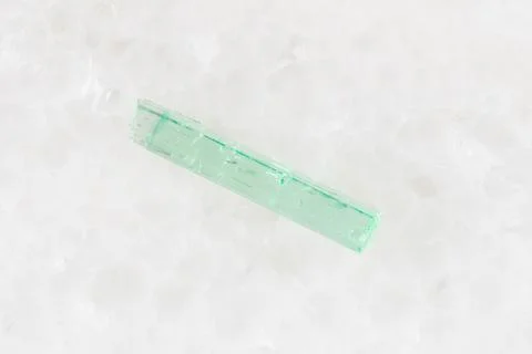 Sample of raw emerald crystal on white marble Stock Photos