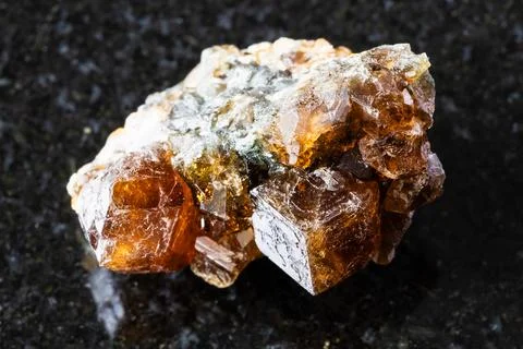 Sample of raw hessonite grossular rock on black Stock Photos