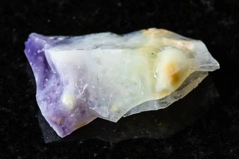 Sample of raw opal mineral on black granite Stock Photos