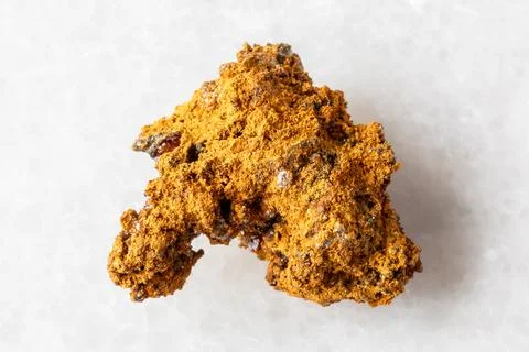 Sample of raw wulfenite ore on white marble Foto stock