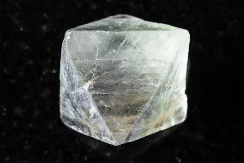 Sample of rough fluorite crystal on black granite Stock Photos