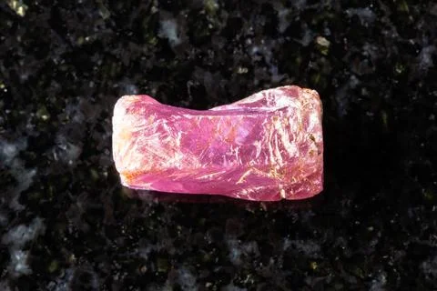 Sample of rough pink ruby crystal on black granite Stock Photos