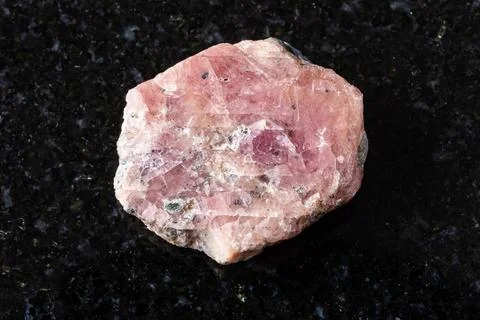 Sample of rough pink ruby mineral on black granite Stock Photos