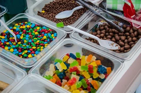 A sample of several candies in plastic containers Stock Photos