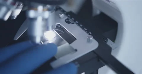 Sample slide and microscope with metal lens at laboratory. Stock Footage 144008684