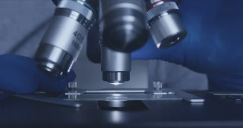 Sample slide and microscope with metal lens at laboratory. Vídeo Stock 144009369