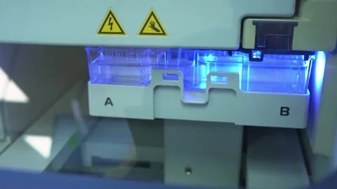 A sample tray lit blue inside a laboratory instrument at a crime laboratory Stock Footage 345299329