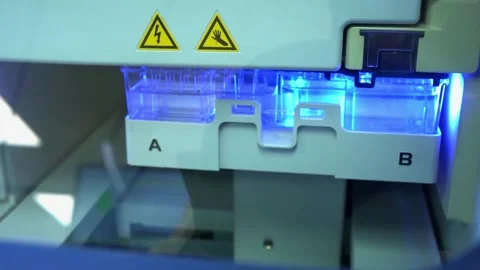 A sample tray lit blue inside a laboratory instrument at a crime laboratory Stock-Footage 345363659