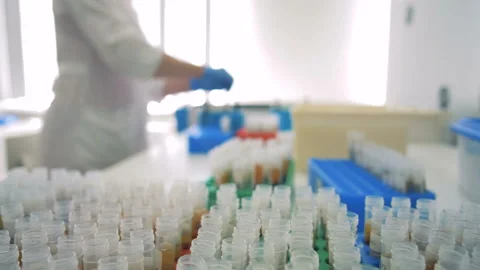 Samples are placed on a table, while a doctor works on a background. HD. Video stock 90985182