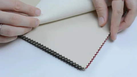 Samples of artificial leather. Women's hands touch the leather for sewing. Stock Footage 157045920