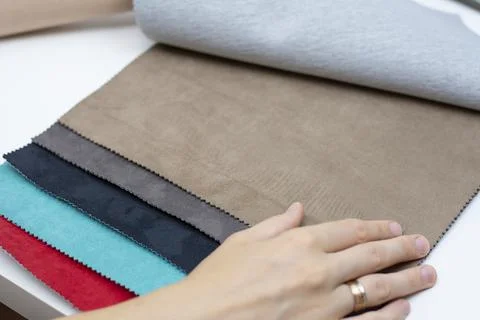Samples of artificial suede. Women's hands on sheets of suede fabric close-up. Foto stock