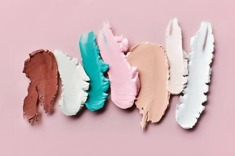 Samples of color correcting concealers Set on pink background. Swatch smears of Stock Photos