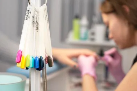 Samples of colored nails in the foreground and in the background manicurist d Foto stock
